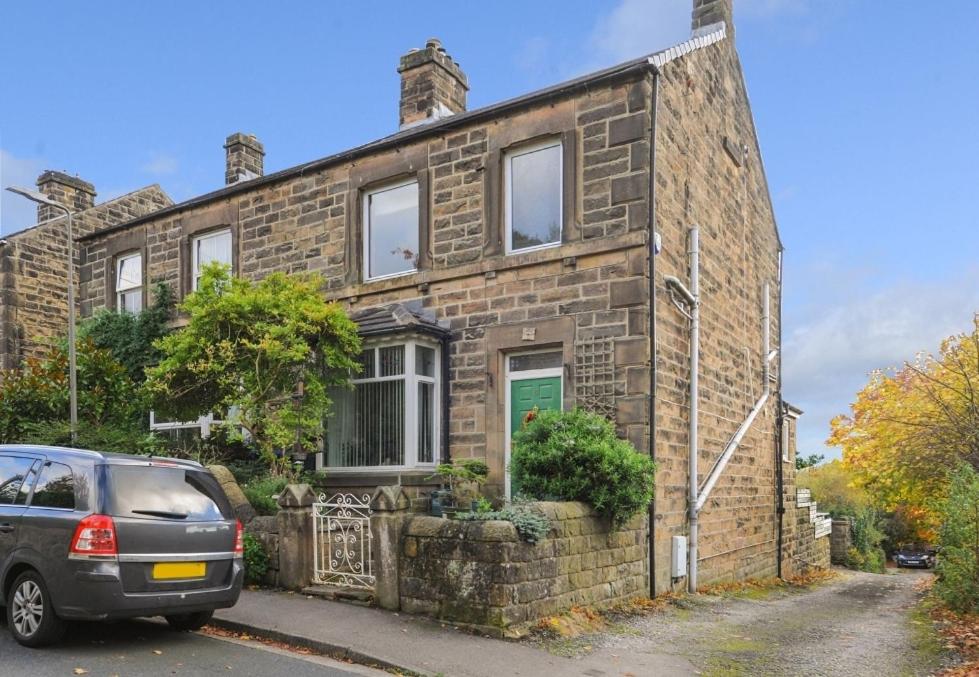 una casa de ladrillo con un coche aparcado delante de ella en Castleside House, en Matlock