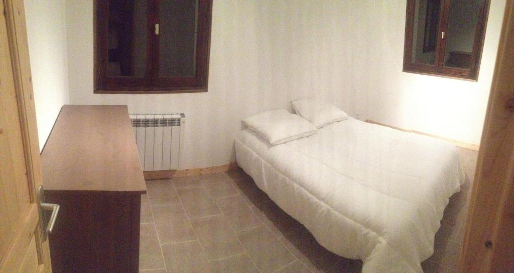 1 dormitorio con cama blanca y mesa en Chalet 6 personnes Gentiane en Les Orres