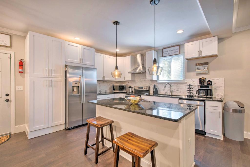 uma cozinha com armários brancos e electrodomésticos de aço inoxidável em Stylish College Park Home with Private Garden! em Atlanta