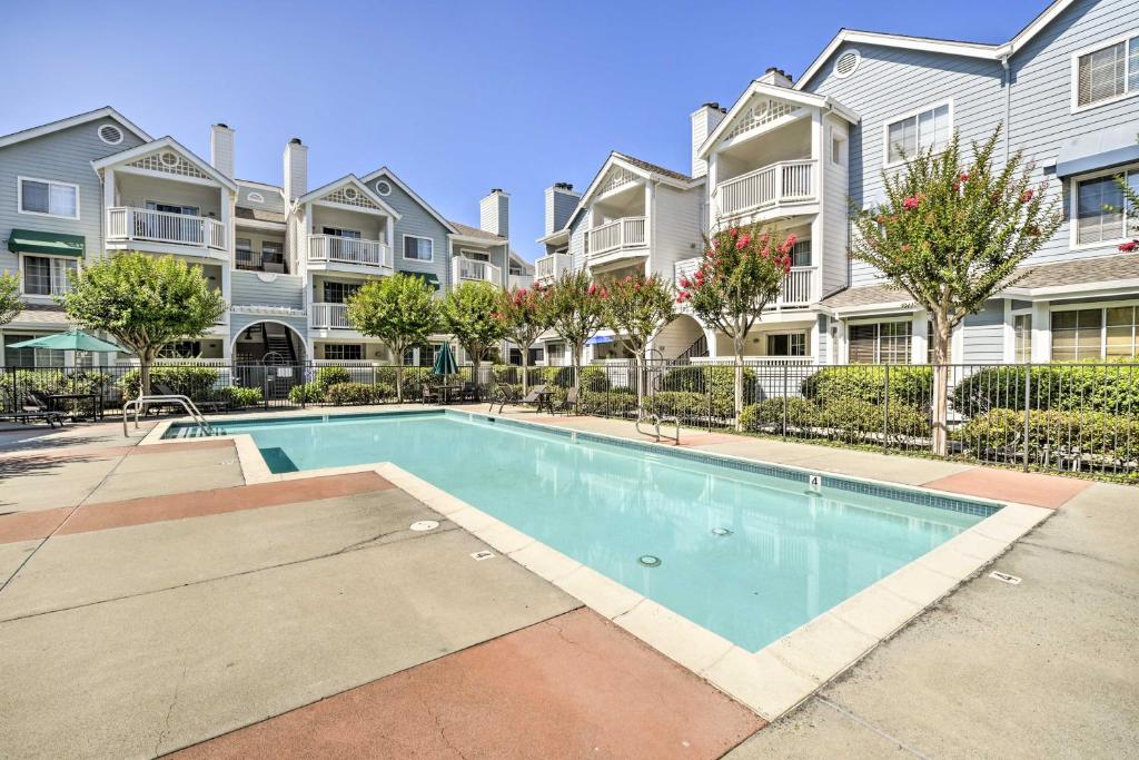 a swimming pool in front of some apartment buildings at Bright Sunnyvale Condo with Community Pool! in Sunnyvale