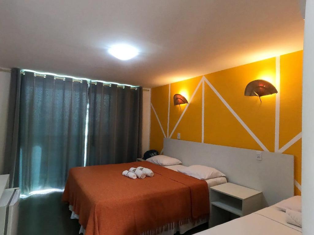 a bedroom with two beds and a yellow wall at Pousada Dotô Sonhadô Beach in Pontas de Pedras