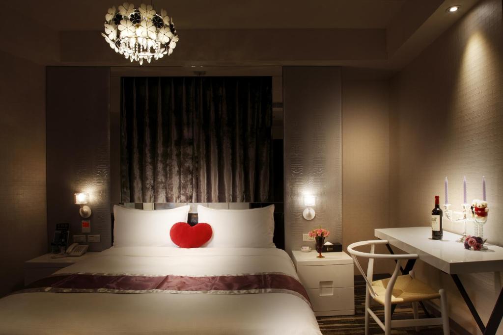 Un dormitorio con una cama con un corazón rojo. en Grace Hotel en Taipéi