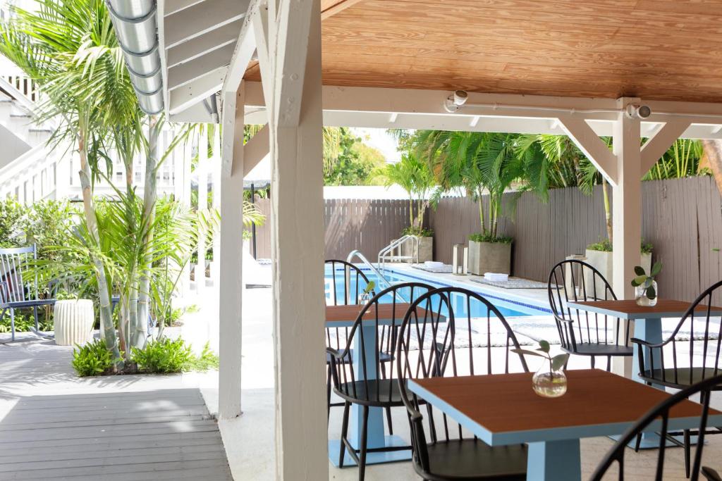 une terrasse avec des tables et des chaises ainsi qu'une piscine dans l'établissement Ridley House - Key West Historic Inns, à Key West