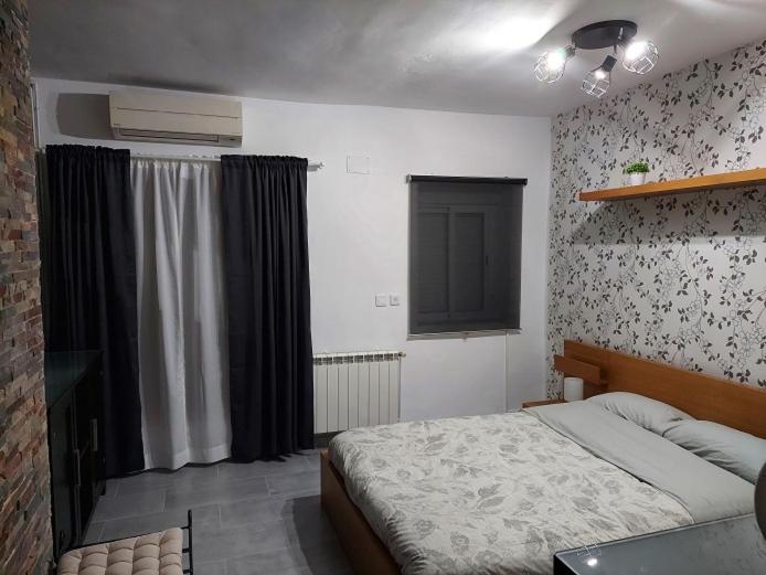 Schlafzimmer mit einem Bett und einem Fenster in der Unterkunft piso acogedor con encanto in Navas del Rey