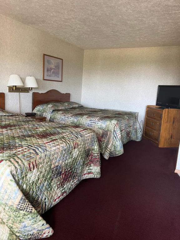 um quarto de hotel com duas camas e uma televisão de ecrã plano em Gray Wolf Lodge em Manistique