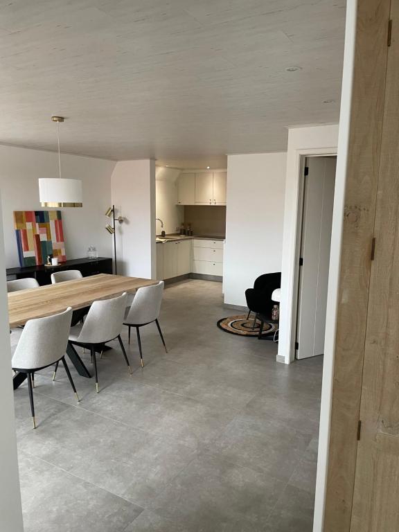 - une salle à manger et une cuisine avec une table et des chaises dans l'établissement Vakantieverblijf De Munt, à Oudenburg
