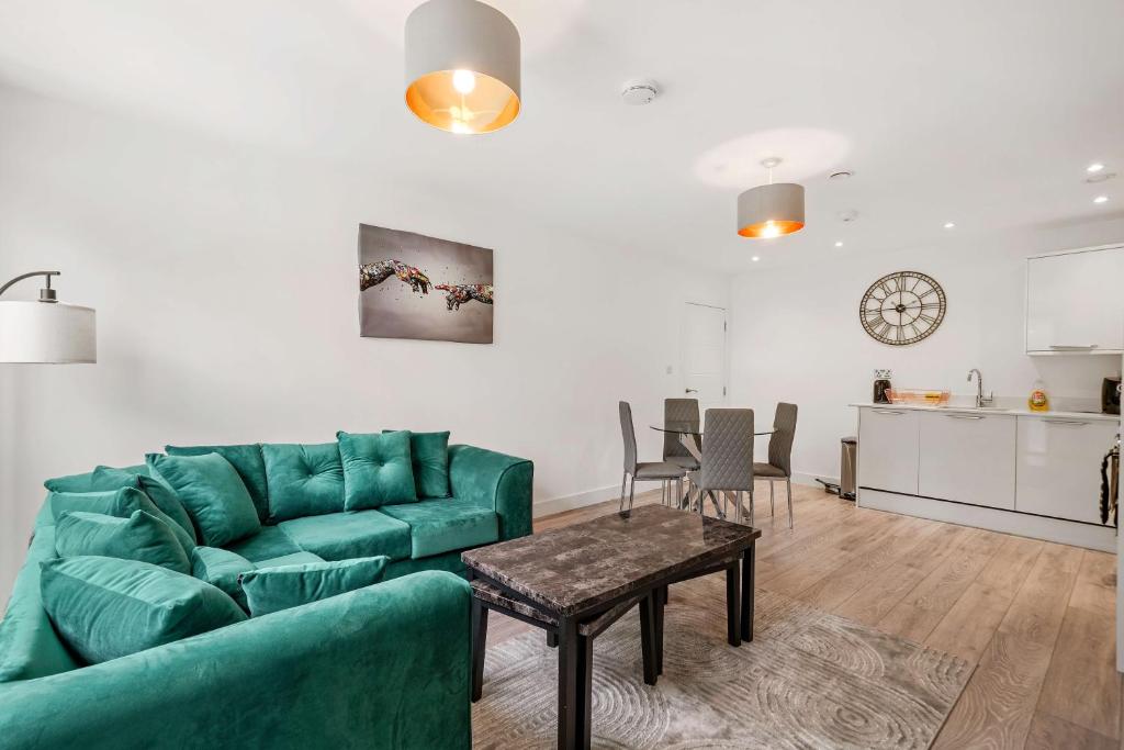 a living room with a green couch and a table at The Arches Watford in Watford