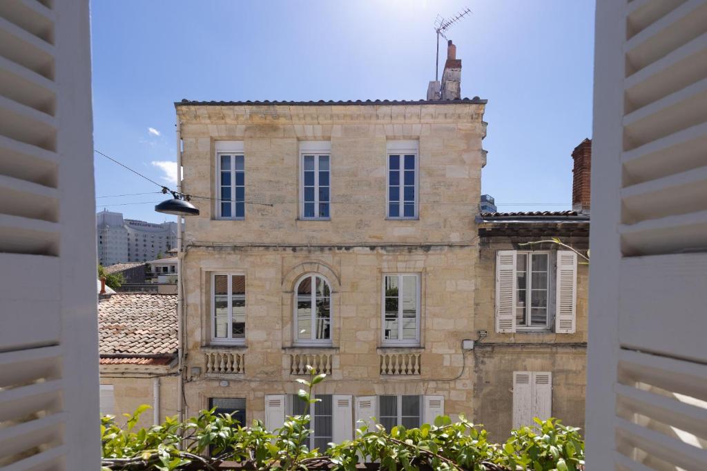 un vieux bâtiment en briques avec une fenêtre dans l'établissement Les Séraphines - Chambres d'hôtes - Guests house, à Bordeaux