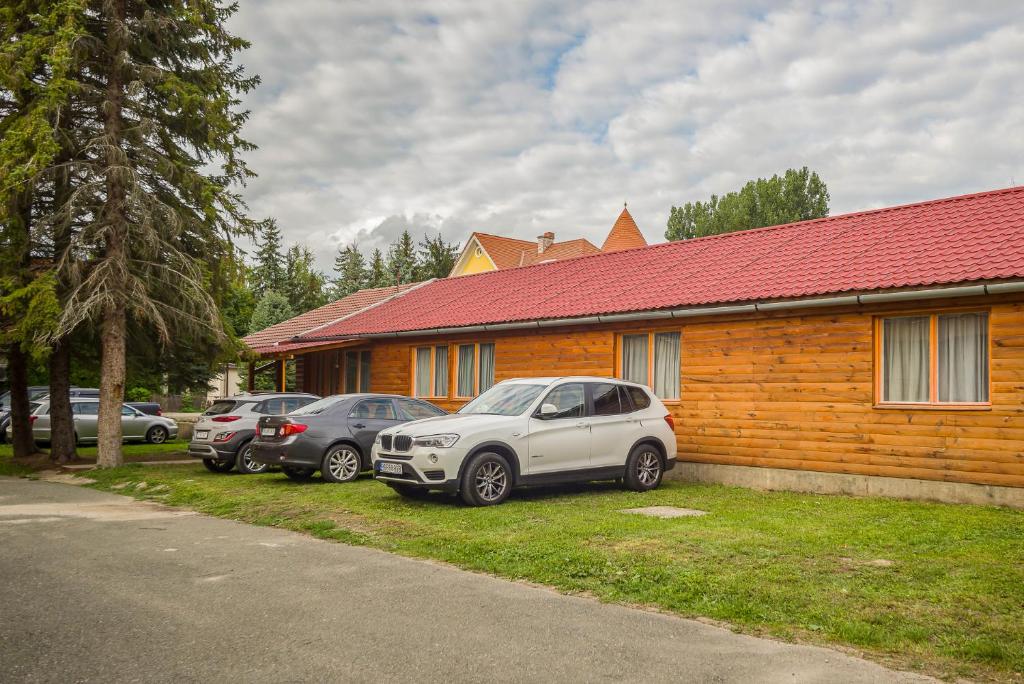 um grupo de carros estacionados em frente a uma casa em Lipicai Ifjúsági Szálló em Szilvásvárad