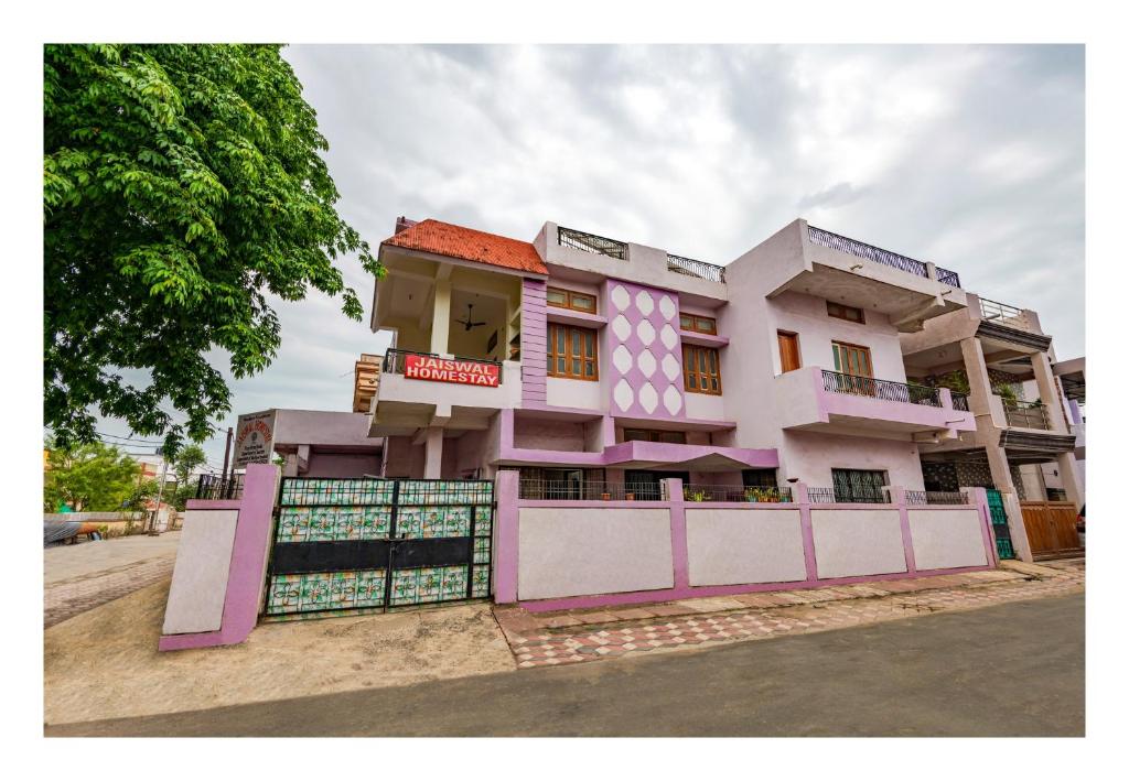 een roze en wit gebouw met een hek bij Jaiswal Homestay Pet friendly Entire Bungalow in Jabalpur