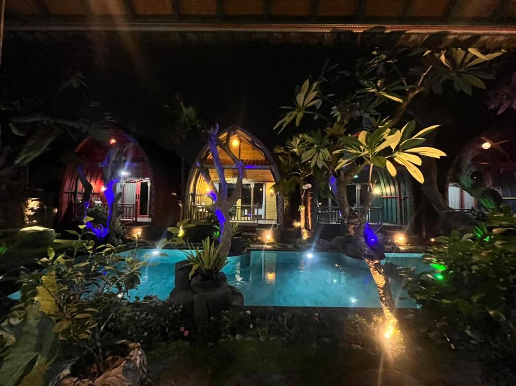 una piscina por la noche con luces azules en Villa Telaga Wana en Sukawati