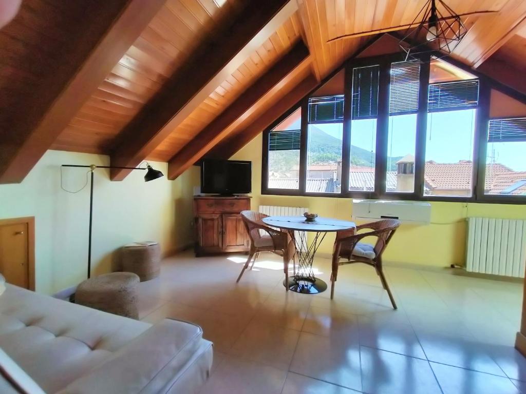 sala de estar con mesa, sillas y ventanas en Apartamento LA LUCANA ORDESA-Laspuña, en Laspuña