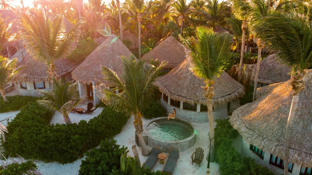 an aerial view of a resort with a swimming pool and palm trees at Maya Tulum By G Hotels in Tulum
