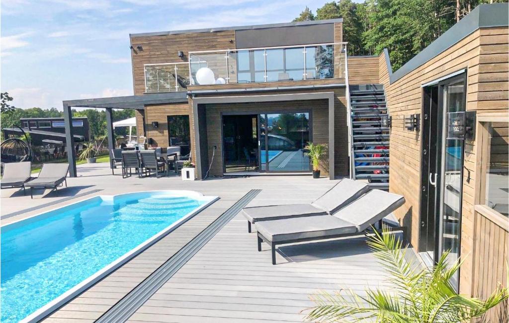 a house with a swimming pool next to a house at Stunning Home In Brevik With Outdoor Swimming Pool, Sauna And Private Swimming Pool in Bjønnes