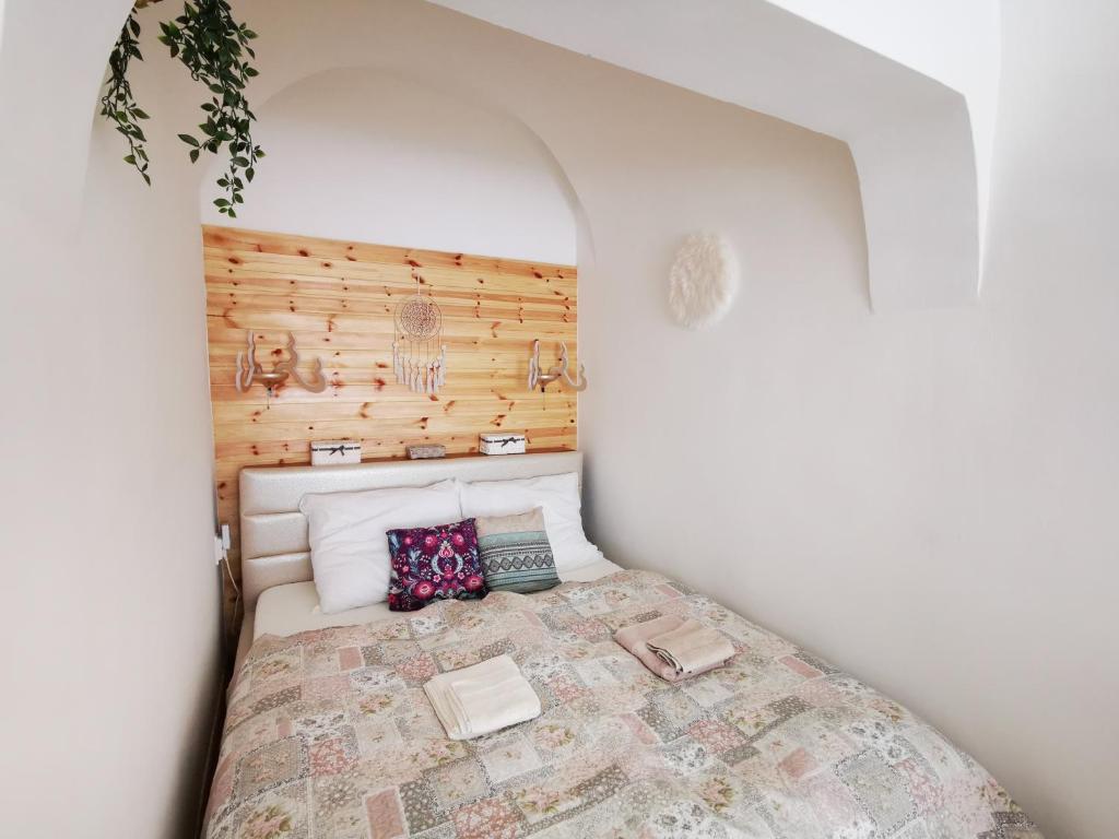 niewielka sypialnia z łóżkiem z drewnianą ścianą w obiekcie Oldtown Shelter Apartment with free private parking w Egerze