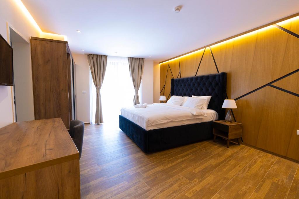 a bedroom with a bed and a desk in a room at Hotel Castello in Prizren