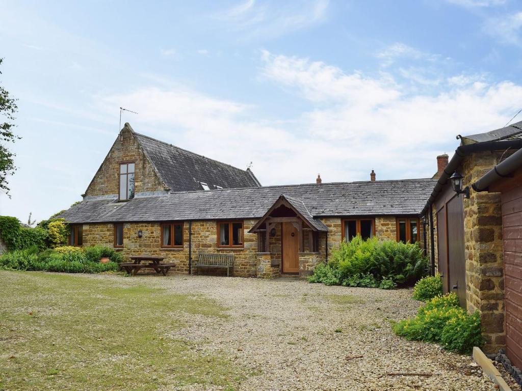 an exterior view of a stone house with a yard at Swallow Barn in Banbury