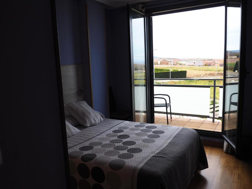 a bedroom with a bed and a view of a balcony at Apartamento Golf Buenas Vistas in Cirueña