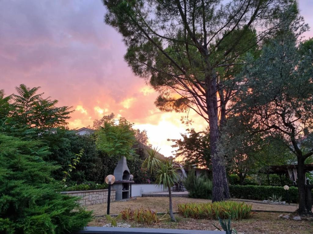 a sunset view of a house with a tree at San Casciano, tra Stifone,le mole e le goledelNera in Narni