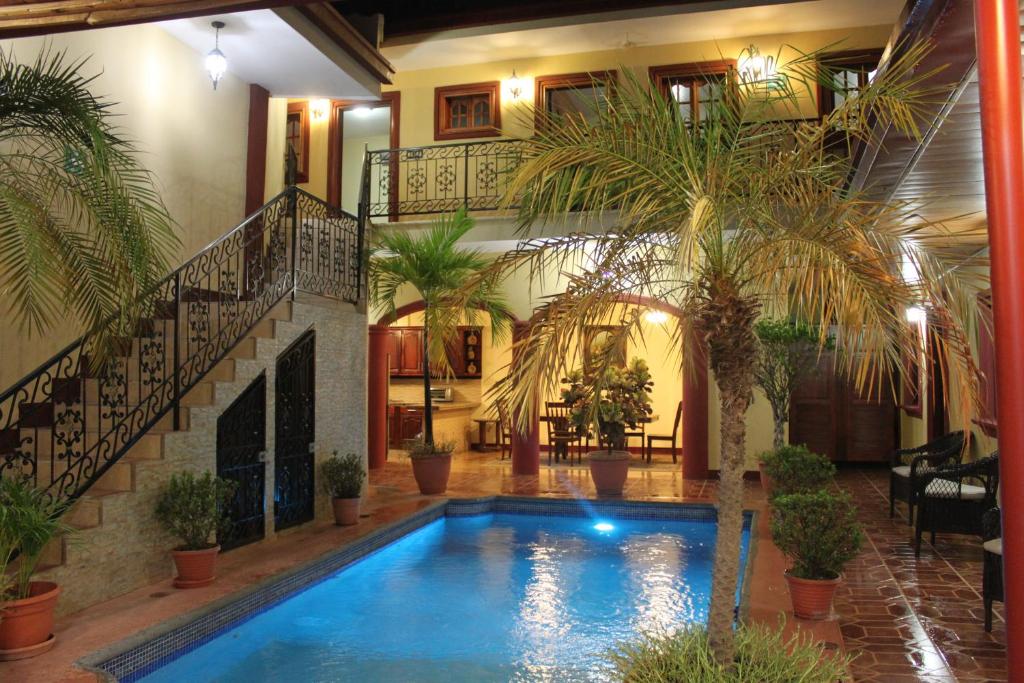 uma piscina numa casa com palmeiras em Hotel Guardabarranco em Granada