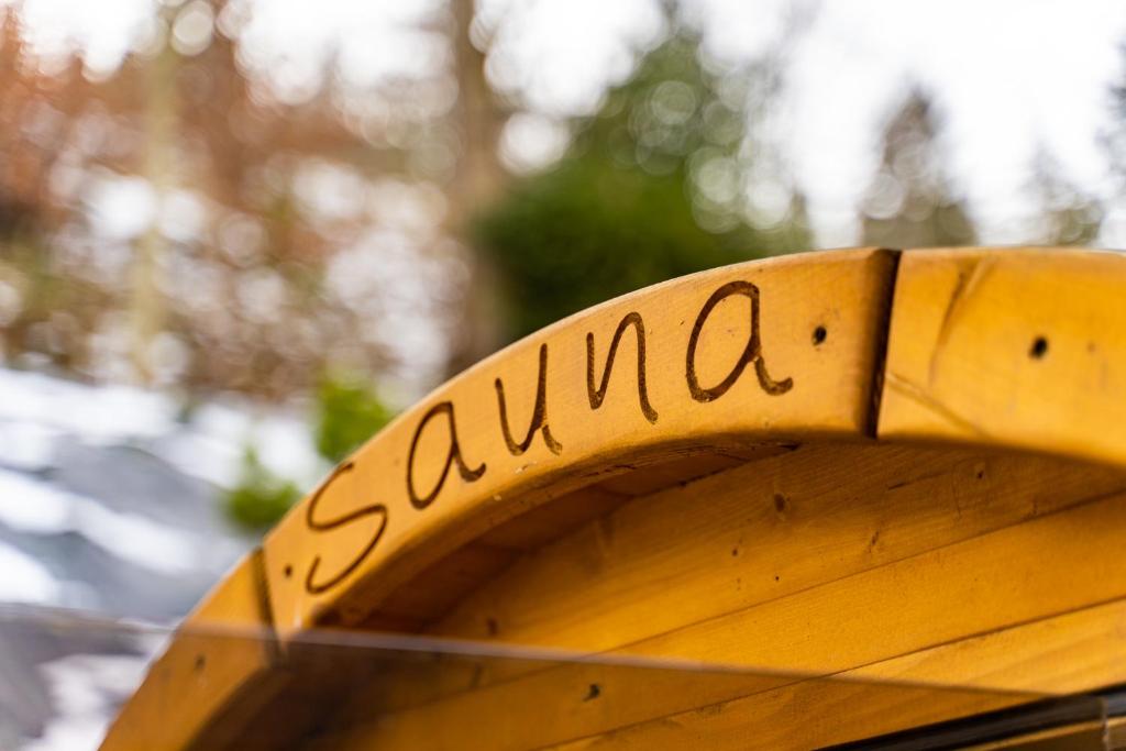 un banco de madera con la palabra samana escrita en él en Z SAUNĄ, BLISKO WYCIĄGU - Osada Wilczy Potok, en Szczyrk
