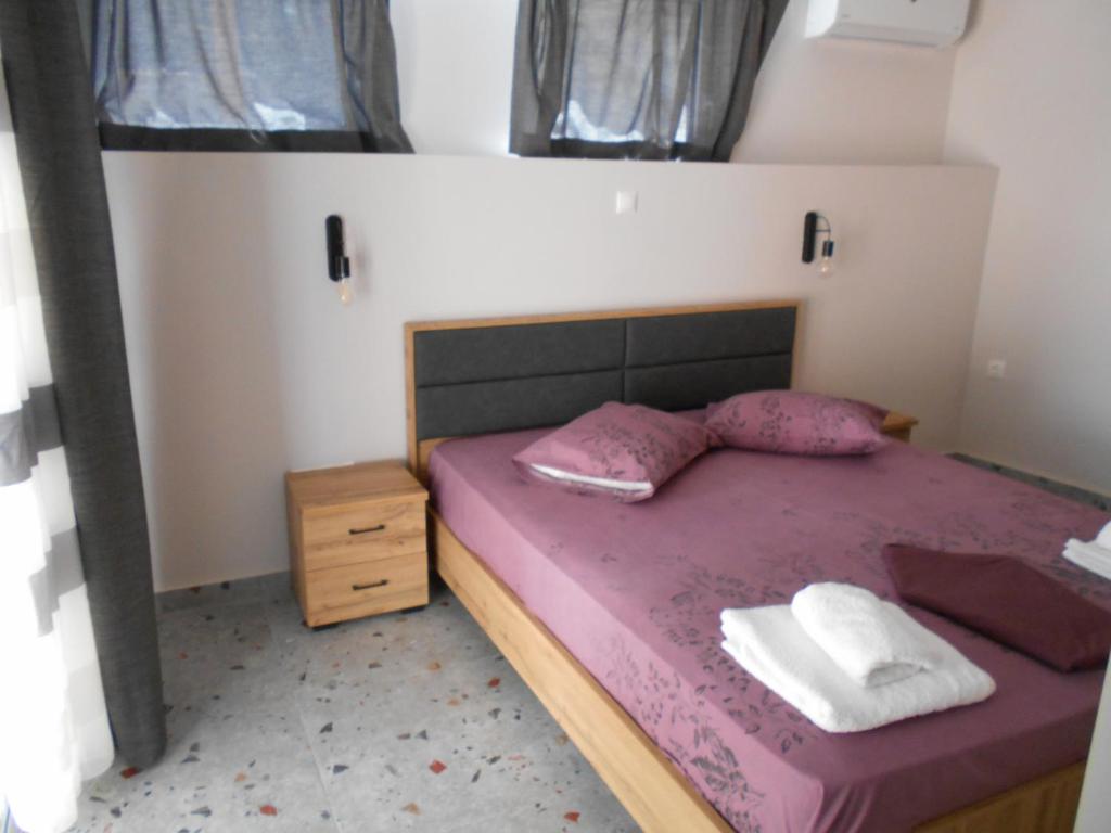 Un dormitorio con una cama con sábanas y almohadas púrpuras. en SPΛCES PYLOS Apartments en Pylos