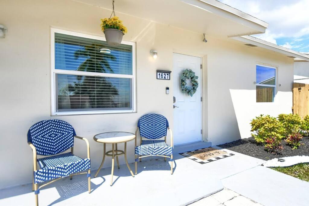 a patio with two chairs and a table in front of a house at Boynton Beach Getaway in Boynton Beach