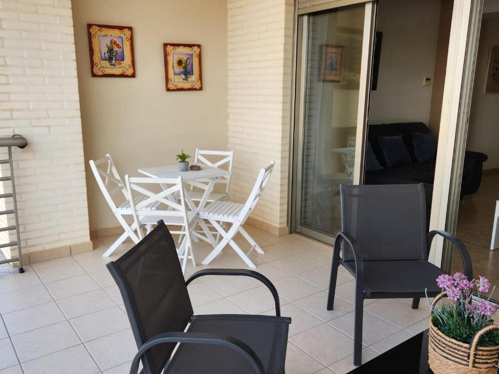 a patio with a table and chairs on a porch at Nuevo apartamento con A A a 2 minutos de la playa MASBO 2 in Moncófar