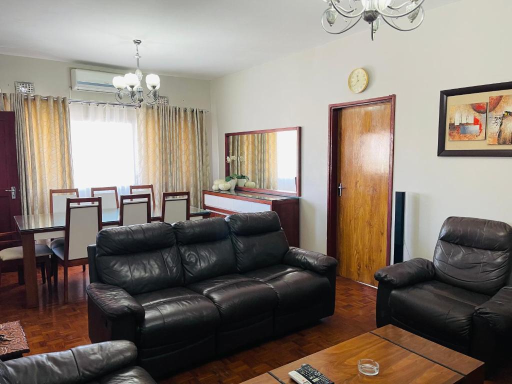 a living room with a couch and a dining room at Januario Maputo in Maputo