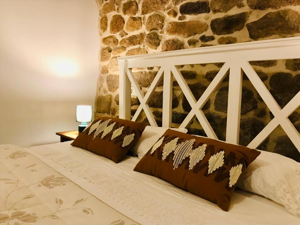een slaapkamer met een bed met een stenen muur bij Loft zona histórica Camino De Santiago in Tui