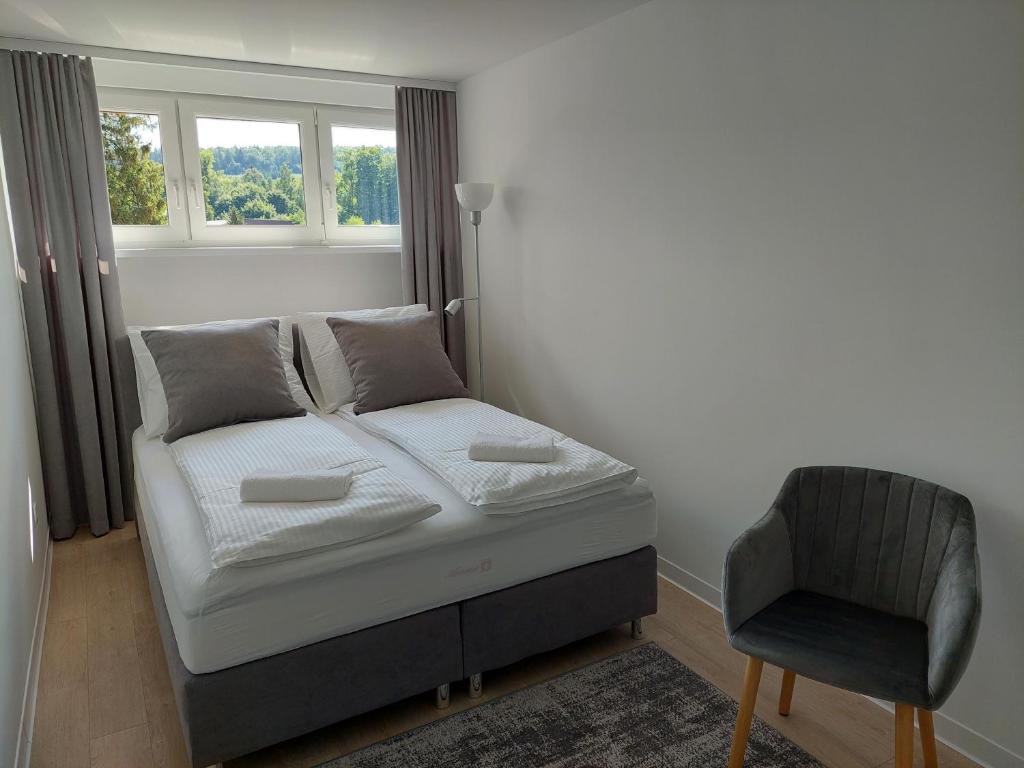 1 dormitorio con 1 cama con silla y ventana en Apartament26 en Stronie Śląskie