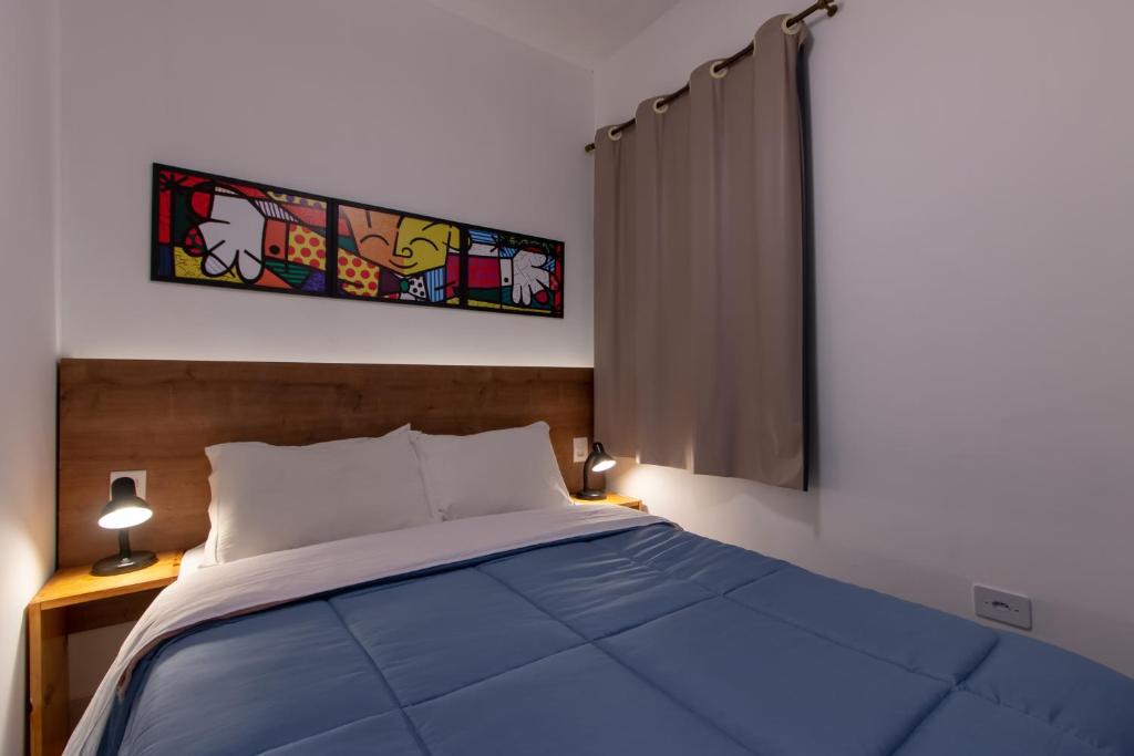 een slaapkamer met een blauw bed en een raam bij Apartamento completo no Brás in Sao Paulo