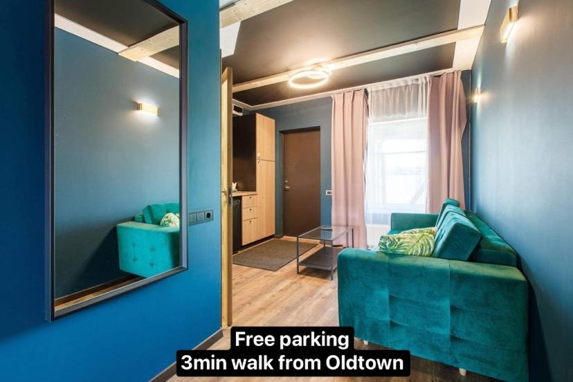 a living room with a blue couch and a mirror at Apartments in Kaunas in Kaunas