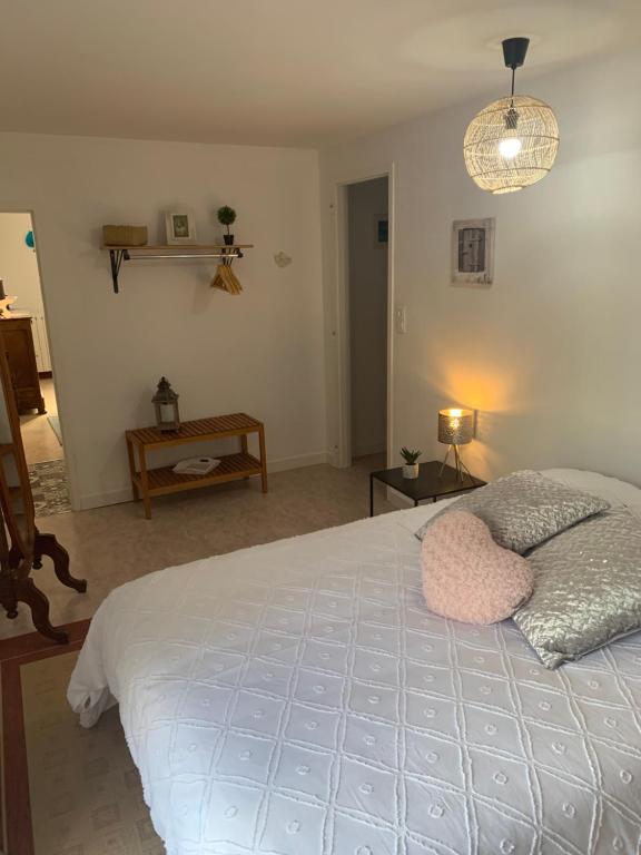 a bedroom with a large bed with a pink pillow at La maison bleue in Remoncourt