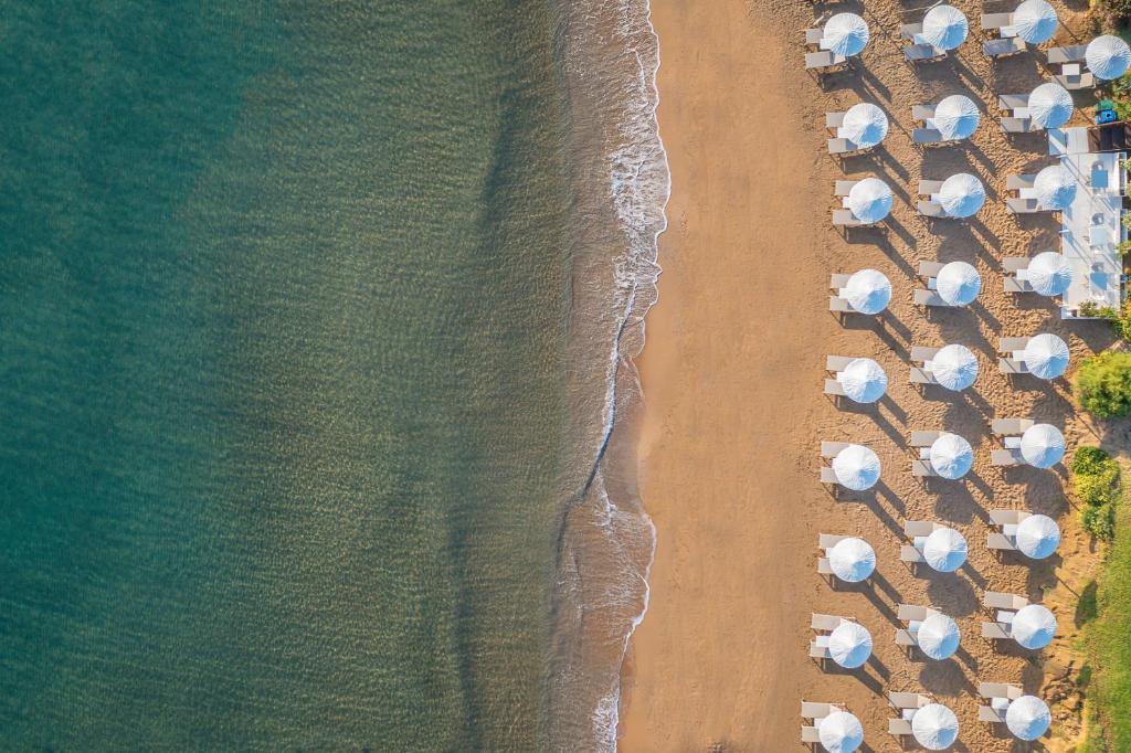 an overhead view of a beach with umbrellas and the ocean at Giannoulis - Santa Marina Plaza (Adults Only) in Agia Marina Nea Kydonias
