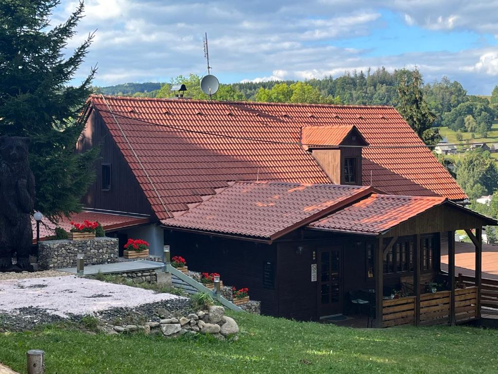 dom z pomarańczowym dachem wyłożonym kafelkami w obiekcie PENZION HARRY na sjezdovce KRKONOŠE w mieście Vysoké nad Jizerou