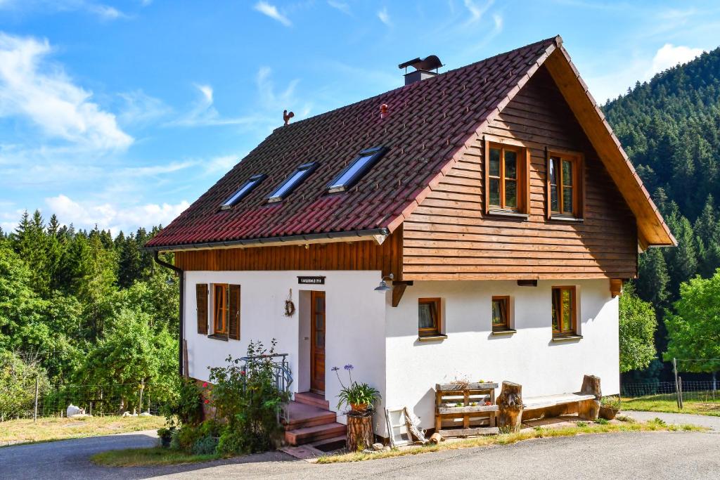 ein kleines weißes Haus mit braunem Dach in der Unterkunft Ferienhaus Müllerswald in Schenkenzell