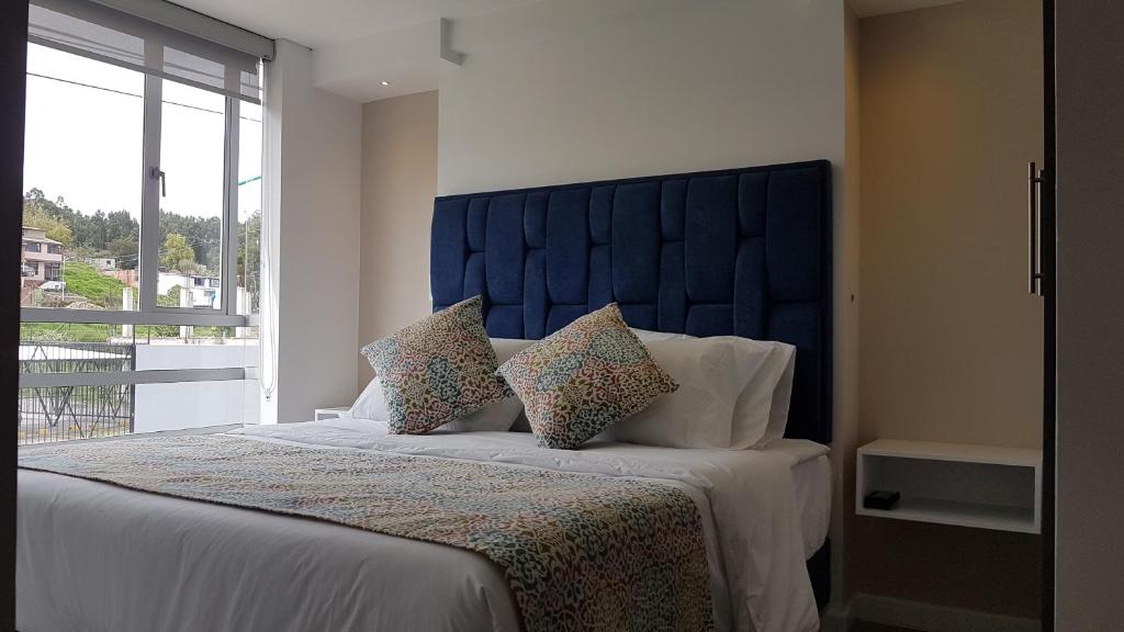 派帕的住宿－Apartamentos Edificio Premium，一间卧室配有一张带蓝色床头板和枕头的床。