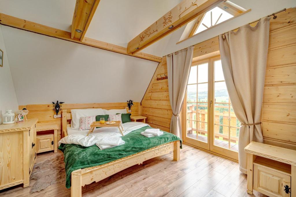 a bedroom with a bed and a desk and a window at Jedlinowo Chata- Domek z balią i kominkiem in Szaflary