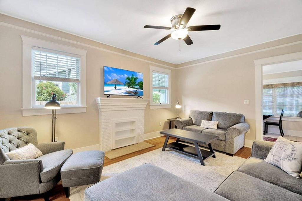 een woonkamer met twee banken en een plafondventilator bij Bayshore Beauty Stylish 3BR SOHO Bungalow near Hyde Park in Tampa