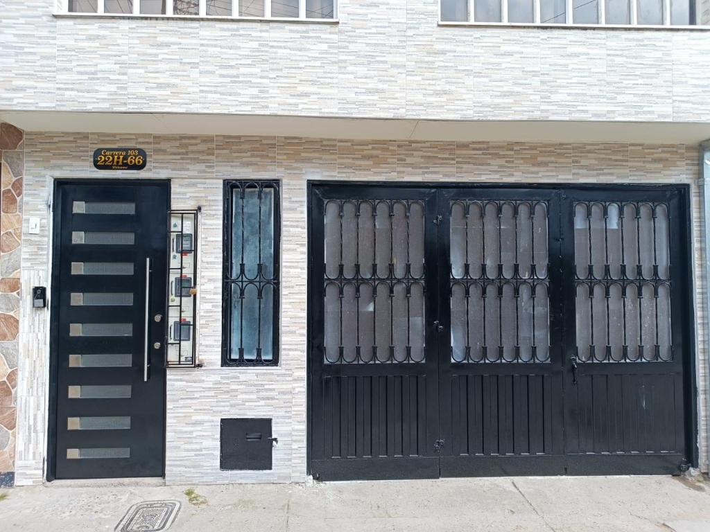 um edifício com uma porta preta e um sinal nele em Hospedaje Room's El Dorado em Bogotá