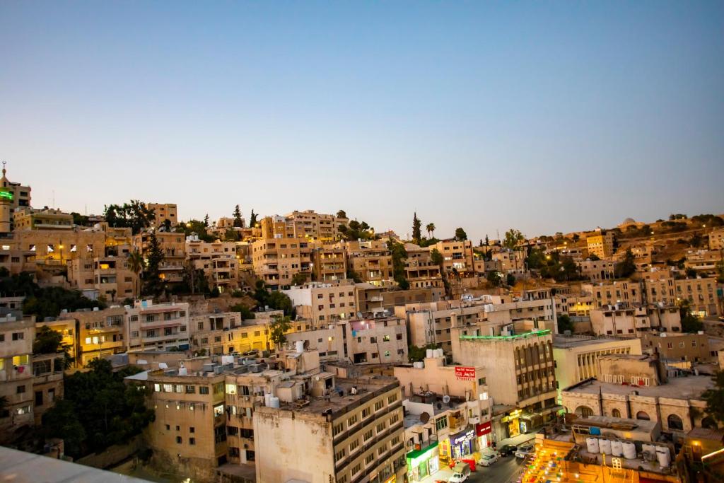a view of a city at night with buildings at Hotel Philosophy in Amman