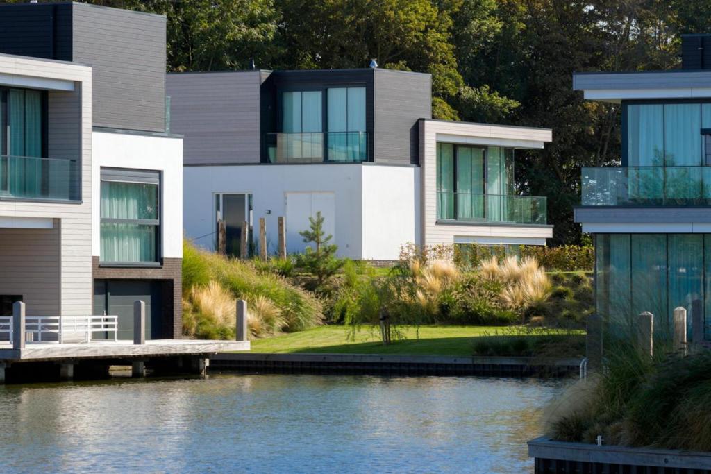 une maison à côté d'une masse d'eau dans l'établissement Lake House with dock at Lake Veere, Zeeland, à Arnemuiden