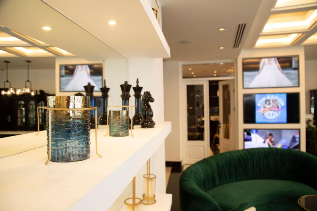 a store with vases on a counter with a green chair at Hotel Philosophy in Amman