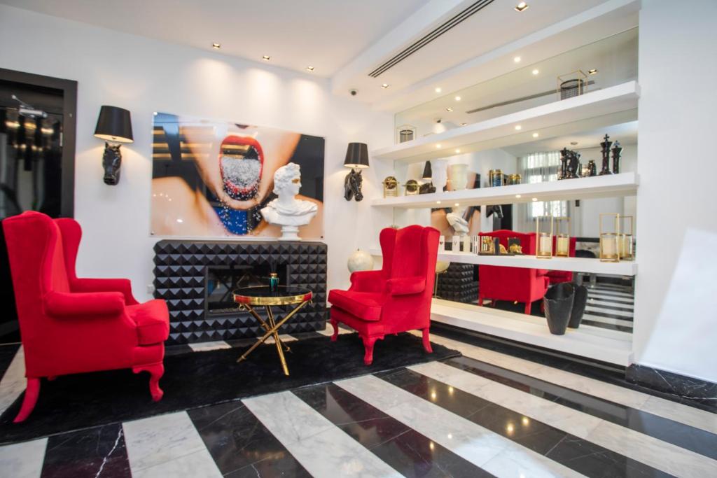 a lobby with red chairs and a fireplace at Hotel Philosophy in Amman