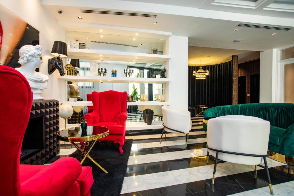 a living room with red and white chairs at Hotel Philosophy in Amman