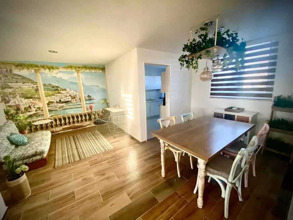 Hotel Muy cómodo y moderno departamento en Zona Andares, a dining room with a wooden table and chairs at Muy cómodo y moderno departamento en Zona Andares in Guadalajara