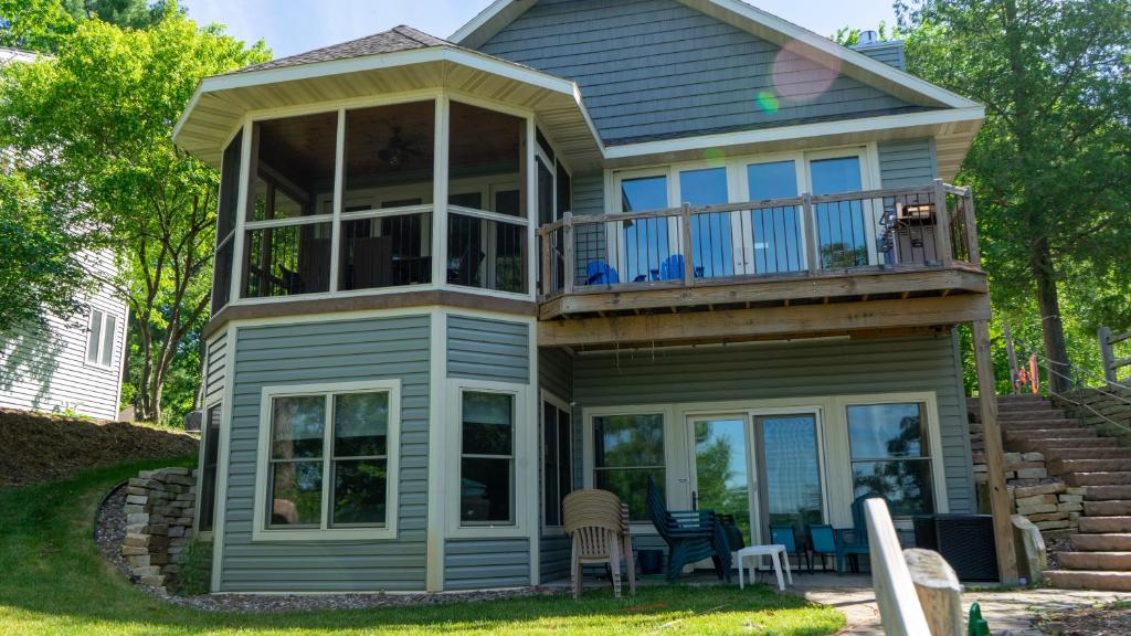 a house with a balcony and a deck at Lakefront Home 4 Bedroom 4 Bath Sleeps 12 in Waupaca