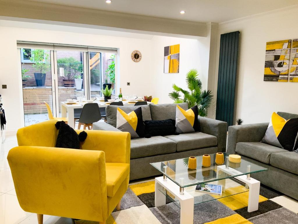 a living room with a couch and yellow chairs at Corbridge Road in Reading