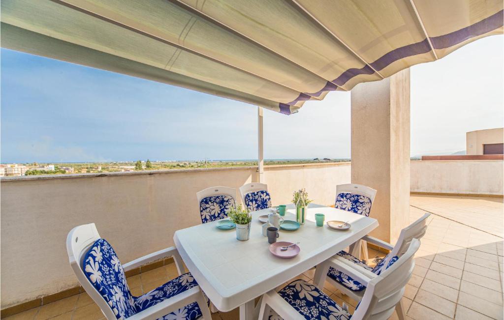 een witte tafel en stoelen met uitzicht op de oceaan bij Lovely Apartment In Torreblanca With Kitchen in Torreblanca